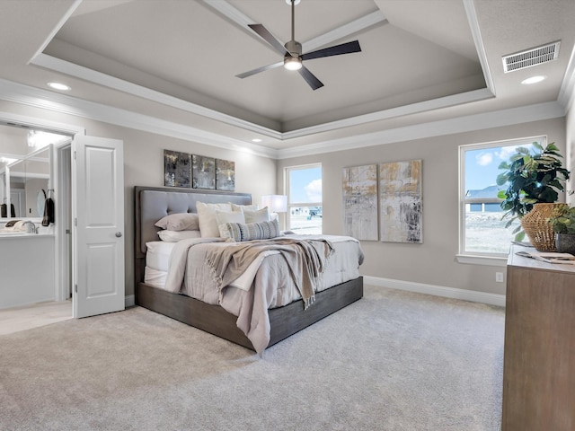 bedroom with ornamental molding, light carpet, ceiling fan, and a tray ceiling