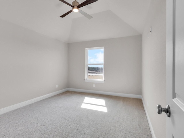 carpeted spare room with ceiling fan and vaulted ceiling