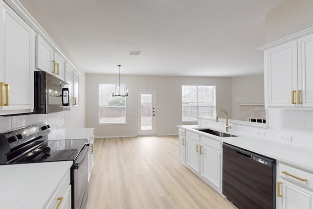 kitchen with white cabinetry, sink, black appliances, and hanging light fixtures