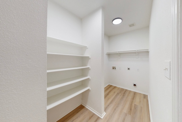 laundry room with electric dryer hookup, hookup for a washing machine, and hardwood / wood-style flooring