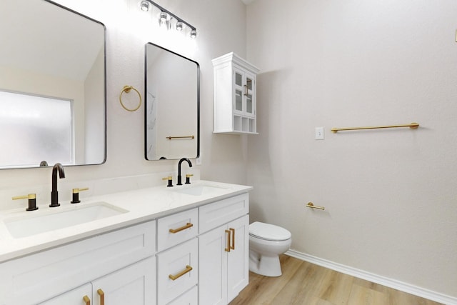 bathroom with wood-type flooring, toilet, and vanity