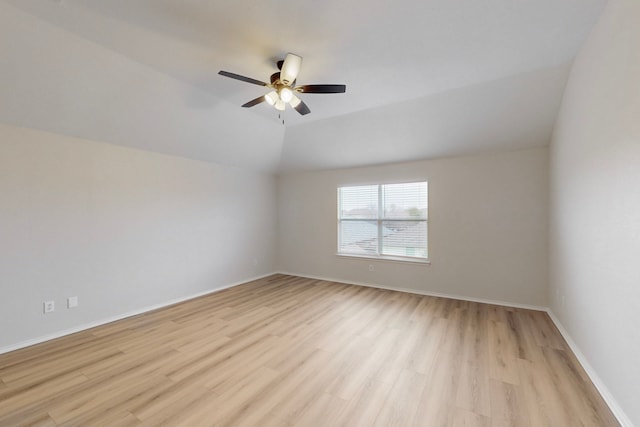 empty room featuring ceiling fan, vaulted ceiling, and light wood-type flooring