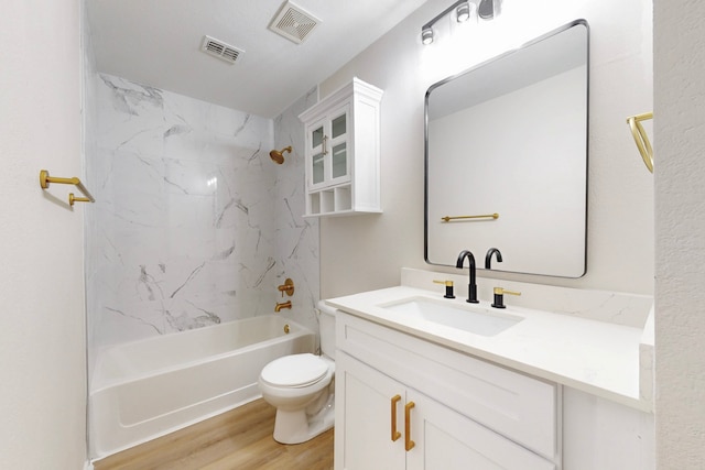 full bathroom with tiled shower / bath, wood-type flooring, vanity, and toilet