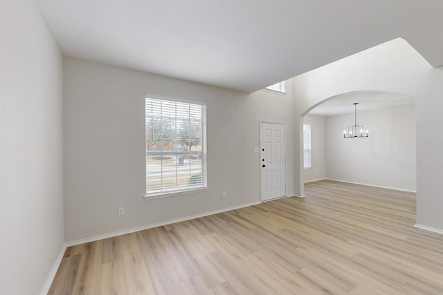 entrance foyer with an inviting chandelier and light hardwood / wood-style floors