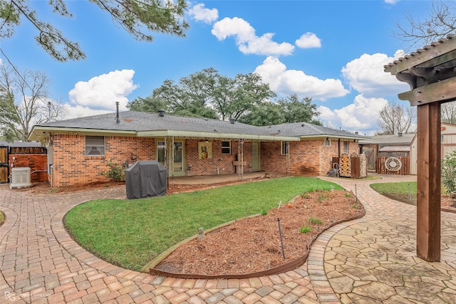 rear view of property with a yard and a patio area