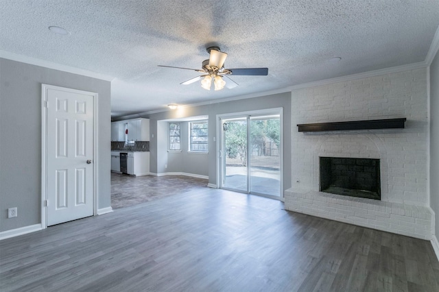 unfurnished living room with a fireplace, ceiling fan, crown molding, dark wood-type flooring, and a textured ceiling