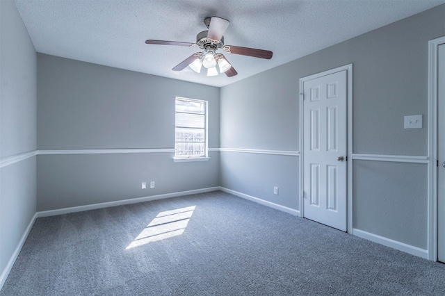 carpeted spare room with ceiling fan and a textured ceiling