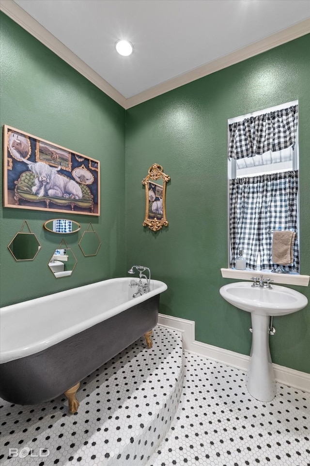 bathroom featuring ornamental molding, tile patterned flooring, a freestanding tub, and baseboards