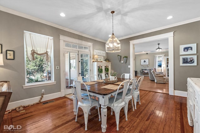 dining area with baseboards, crown molding, visible vents, and wood finished floors