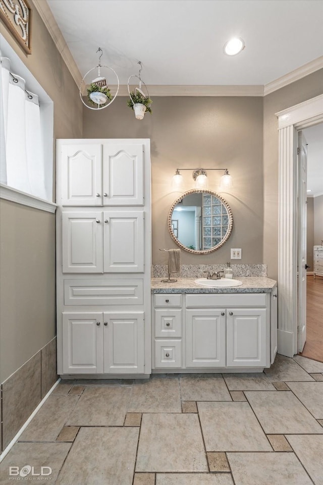 bathroom with ornamental molding and vanity