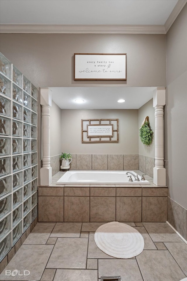 bathroom featuring a garden tub, crown molding, and ornate columns