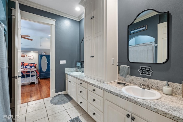 ensuite bathroom featuring a sink, ornamental molding, tile patterned floors, double vanity, and ensuite bath