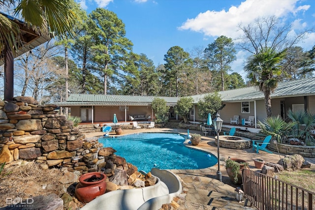 view of swimming pool featuring a patio area and a fire pit