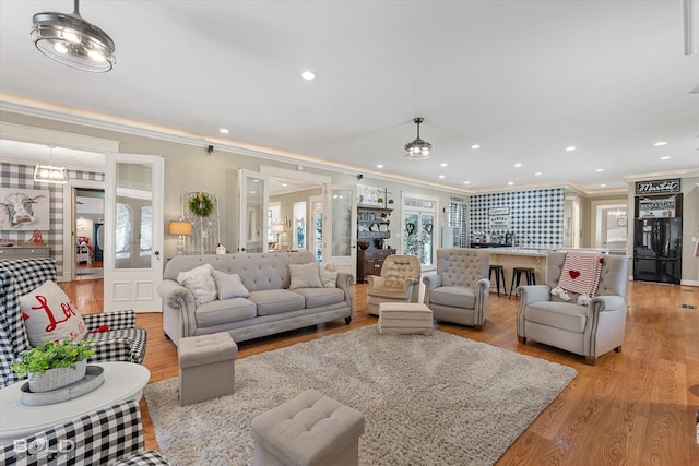 living room with french doors, light wood-type flooring, recessed lighting, and crown molding