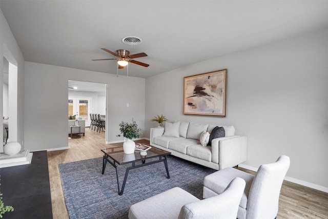 living room featuring wood-type flooring and ceiling fan