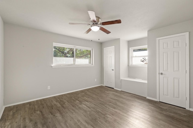 unfurnished bedroom with dark wood-type flooring, ceiling fan, and multiple windows