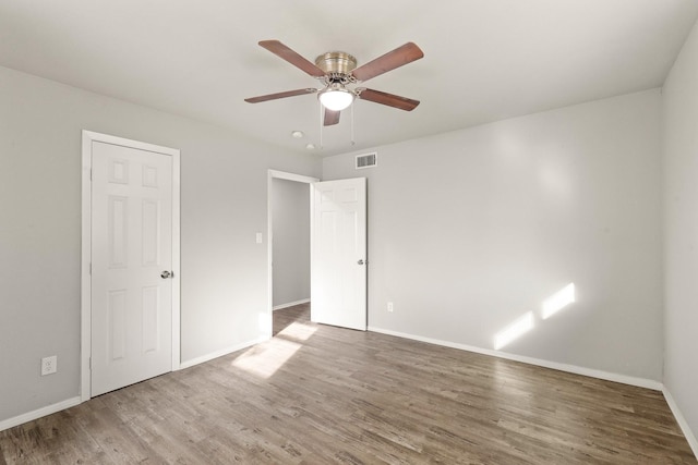 empty room featuring wood-type flooring and ceiling fan