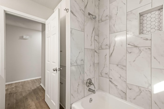 bathroom featuring tiled shower / bath combo and hardwood / wood-style flooring