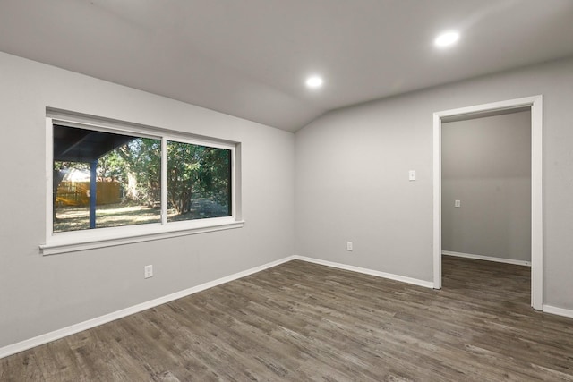 empty room featuring dark hardwood / wood-style flooring and lofted ceiling