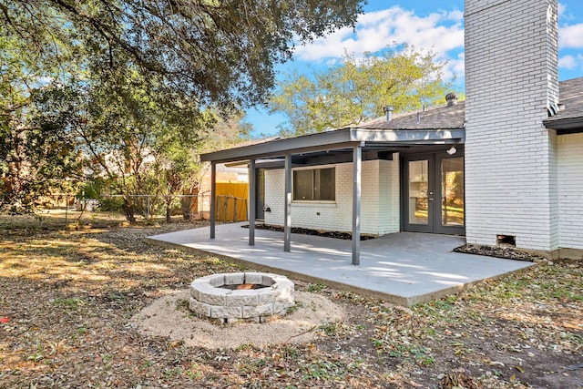 rear view of property with french doors, an outdoor fire pit, and a patio