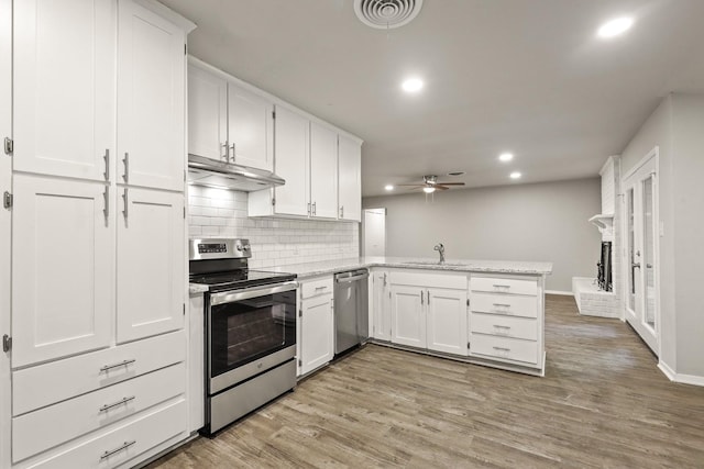 kitchen with stainless steel appliances, sink, white cabinets, and kitchen peninsula