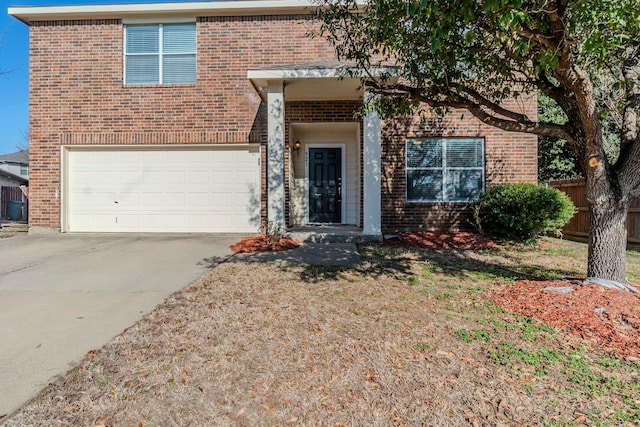 traditional-style home featuring concrete driveway, brick siding, fence, and an attached garage