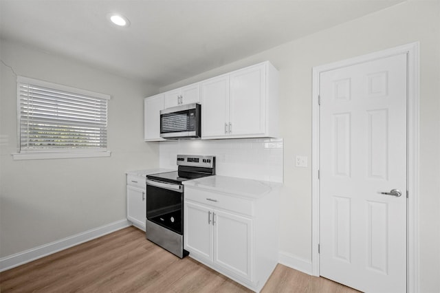 kitchen featuring stainless steel appliances, light hardwood / wood-style flooring, white cabinets, and decorative backsplash