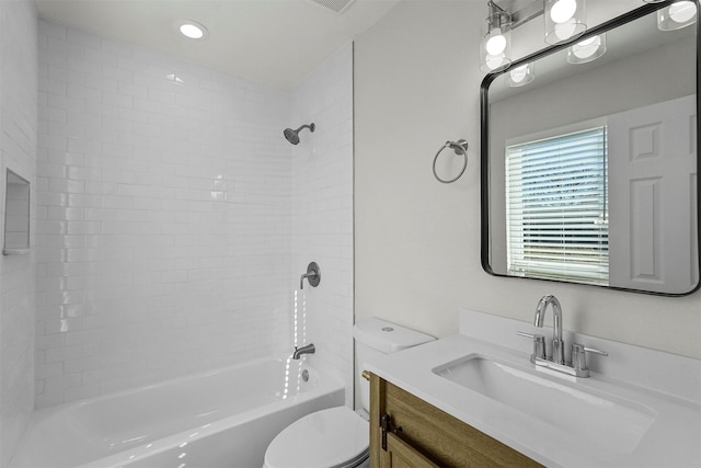 full bathroom with vanity, tiled shower / bath, and toilet