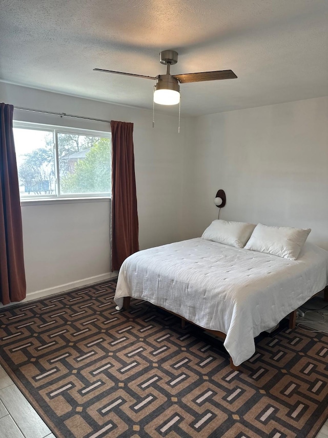 bedroom featuring ceiling fan and a textured ceiling