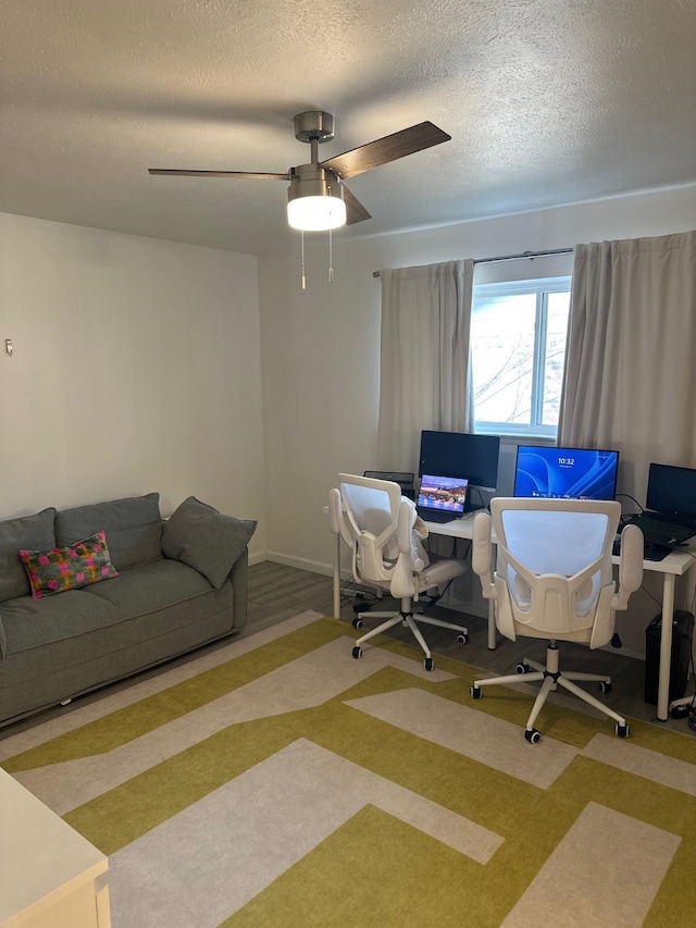 carpeted home office featuring ceiling fan and a textured ceiling