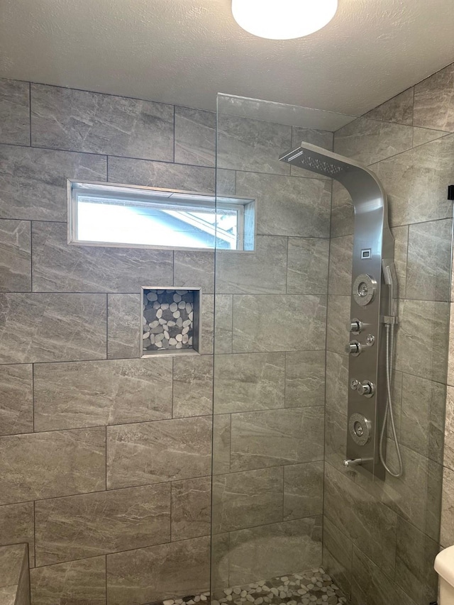 bathroom featuring a healthy amount of sunlight and a tile shower