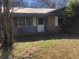 view of front of house with metal roof and a front lawn