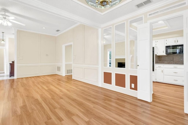 empty room featuring ceiling fan, ornamental molding, and light hardwood / wood-style floors