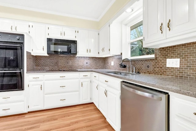 kitchen featuring white cabinetry, sink, black appliances, crown molding, and light hardwood / wood-style flooring