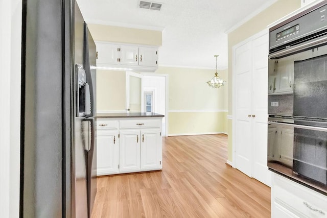 kitchen featuring tasteful backsplash, black appliances, light hardwood / wood-style flooring, pendant lighting, and white cabinets