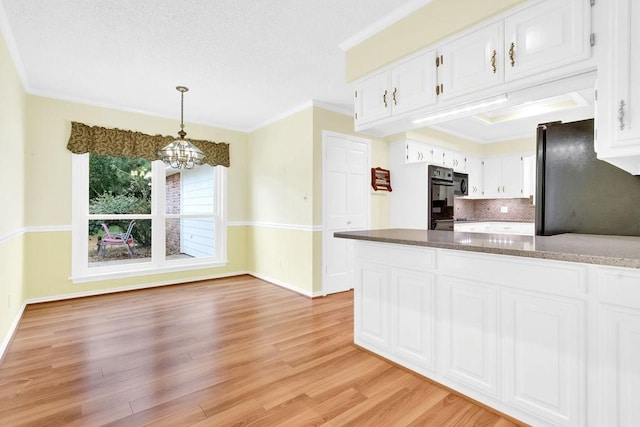 kitchen with ornamental molding, pendant lighting, white cabinets, and light hardwood / wood-style floors