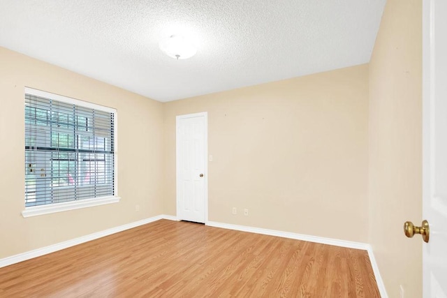 unfurnished room with wood-type flooring and a textured ceiling