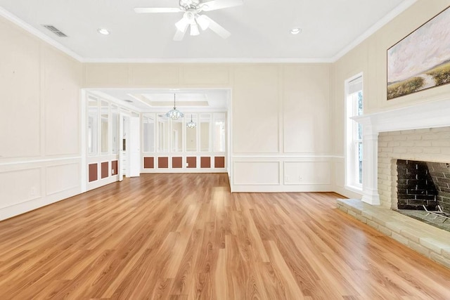 unfurnished living room featuring crown molding, ceiling fan, light hardwood / wood-style floors, and a brick fireplace