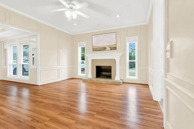 unfurnished living room featuring a brick fireplace, plenty of natural light, and ornamental molding