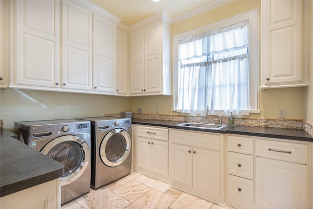 clothes washing area with cabinets, washer and clothes dryer, sink, and a wealth of natural light