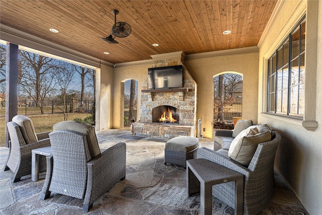 view of patio / terrace with ceiling fan and an outdoor stone fireplace