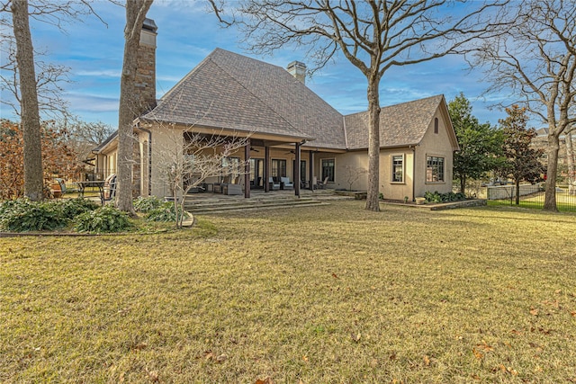 back of house featuring a patio area and a lawn