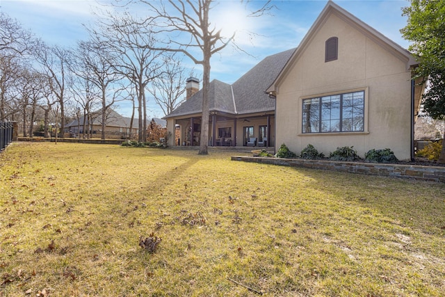 back of house featuring a lawn