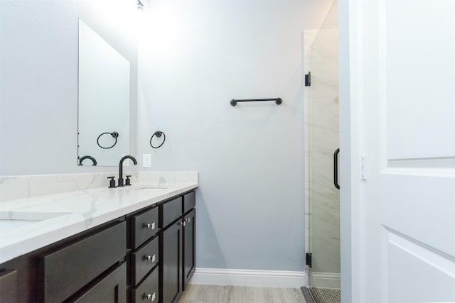 bathroom with hardwood / wood-style flooring, vanity, and a shower with shower door