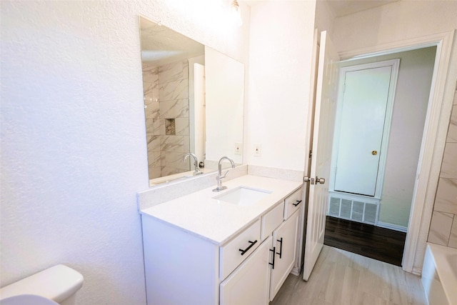 bathroom featuring vanity, wood-type flooring, and toilet