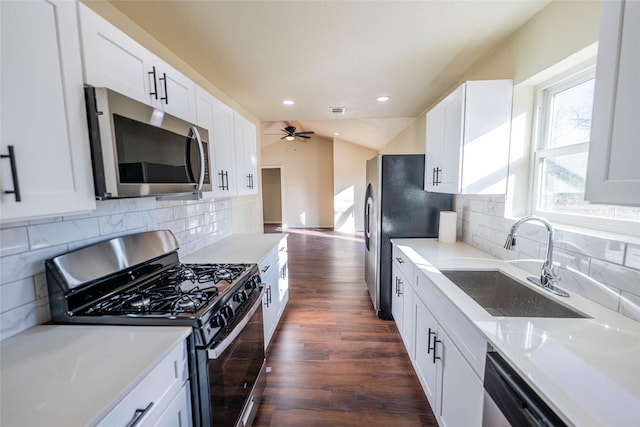 kitchen with sink, white cabinets, dark hardwood / wood-style flooring, ceiling fan, and stainless steel appliances