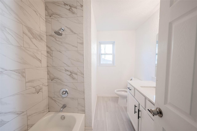 full bathroom with tiled shower / bath, vanity, toilet, and wood-type flooring