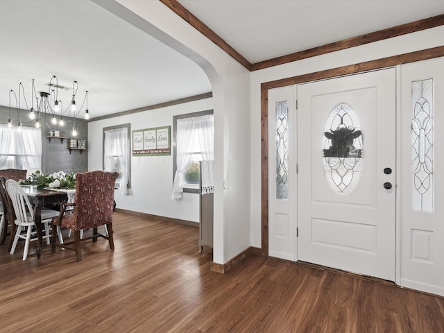 foyer with ornamental molding and dark hardwood / wood-style floors