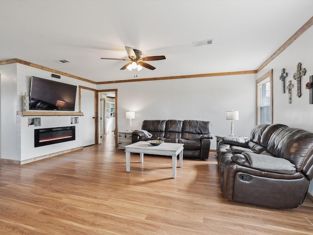 living room featuring crown molding, ceiling fan, and light hardwood / wood-style flooring