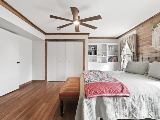 bedroom with hardwood / wood-style flooring, ornamental molding, ceiling fan, and a closet